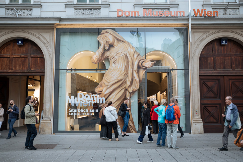 Der Eingang des Dom Museum Wien am Stephansplatz, mit dem Ausstellungssujet für "Sterblich sein". Foto: Marlene Fröhlich Der Eingang des Dom Museum Wien am Stephansplatz, mit dem Ausstellungssujet für "Sterblich sein". Foto: Marlene Fröhlich